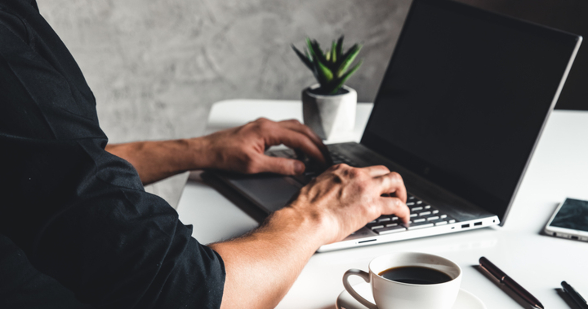 A man typing on a laptop